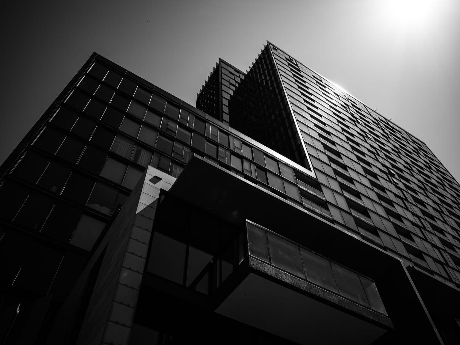 A modern skyscraper photographed from below against a bright sky.